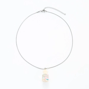 Macro view of silver snake chain with transparent drift bottle pendant and colorful sequins