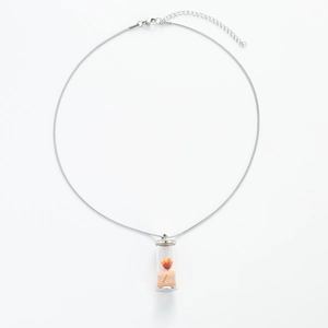 Dettaglio della collana a catena d'argento con fiori secchi arancioni in boccetta