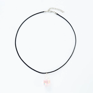 Detail of creative glass bottle necklace with pink liquid and black braided cord