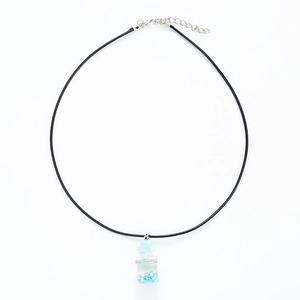 Detail of drift bottle necklace with blue star sequins and black wax cord closure