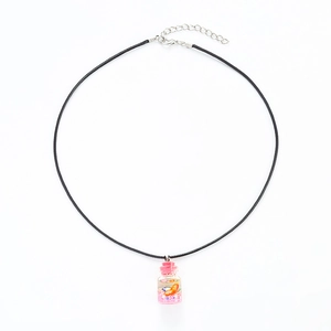 Macro detail of drift bottle pendant with pink star sequins and orange fruit slice
