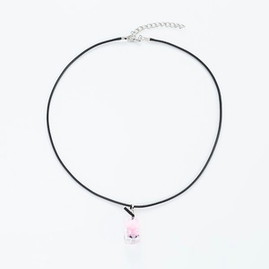 Detailed view of pink resin bear pendant on a black cord necklace with silver lobster clasp