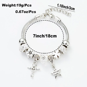 Detail eines Perlenarmbands mit geflügeltem Herzschlüssel und graviertem Sternanhänger aus Silber