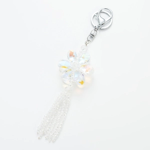 Macro shot of iridescent crystal flower keychain with silver tassel and faceted petals