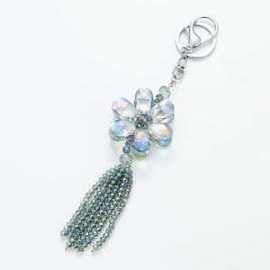 Macro shot of colorful crystal flower keychain with long beaded tassel and silver clasp