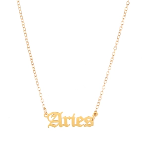 Gedetailleerde opname van gouden Aries hanger in gotisch lettertype met een fijne ketting