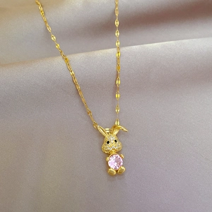 Vergulde konijnenketting met roze zirkoon op een champagne satijnen achtergrond