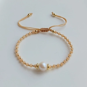 Detail eines Perlenarmbands mit Champagner-Kristallen und einer weißen Süßwasserperle
