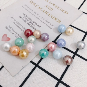Perlas de colores de medio agujero para joyería DIY sobre fondo de cuadros