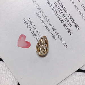 Detalle de cuenta acrílica de gota con patrón floral dorado para creación de joyas DIY
