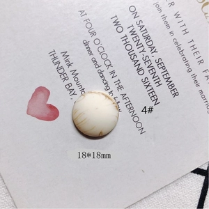 Vista macro de abalorio redondo de resina crema de 18mm con textura de mármol para joyas