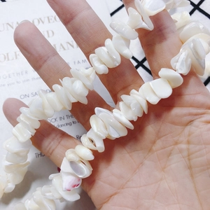 Onregelmatige witte schelpkralen voor DIY sieraden maken in hand gepresenteerd