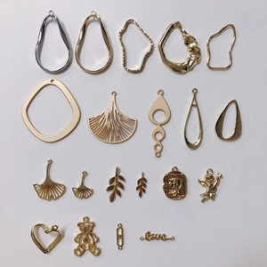Macro shot of assorted gold and silver DIY alloy pendants in bear and leaf shapes
