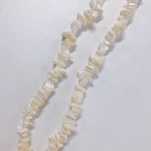 Macro-detail van onregelmatige crème schelpkralen voor het maken van DIY-sieraden