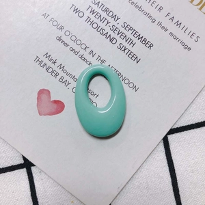 Close-up of mint green oval resin pendant with hollow center and smooth jelly texture