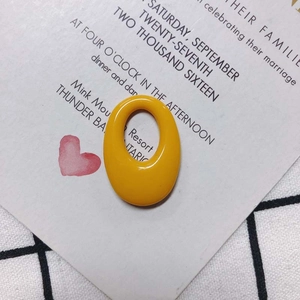Macro view of bright yellow oval resin charm with glossy finish for DIY jewelry crafting