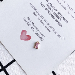 Macro detail of a pink rectangular crystal pendant with gold-plated setting and jump ring
