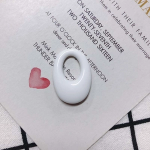 Detailed close-up of white oval resin pendant components with a high-polished ceramic finish
