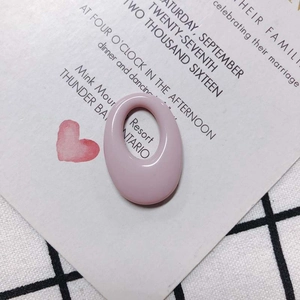 Macro detail of light pink oval resin earring pendant with smooth matte finish