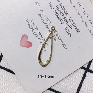 Detail view of a 40x13mm gold plated hollow teardrop metal pendant with a connector loop