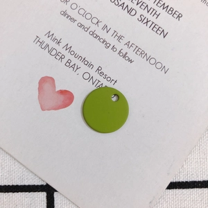 Detail of matte green round alloy charm with a pre-drilled hole for DIY jewelry making
