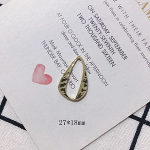Close-up of gold plated teardrop alloy pendant with hammered texture, size 27x18mm