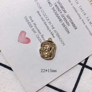 Macro detail of a 22x15mm golden vintage rectangle pendant with female portrait relief