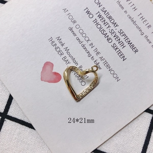 Detail of a 24x21mm golden hollow heart pendant with textured inner finish for DIY jewelry