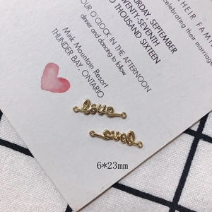 Macro detail of gold-plated love letter jewelry connectors measuring 6 by 23mm