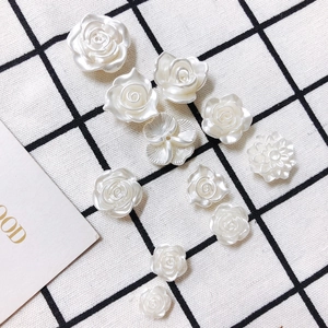 Gros plan de fleurs en résine blanc perle et breloques de roses pour bijoux DIY