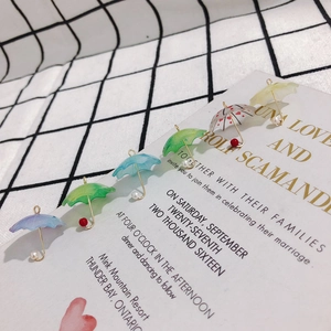 Macro shot of colorful resin umbrella charms with gold accents and pearl details