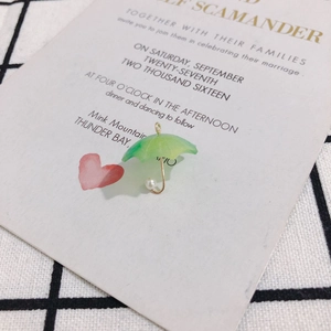 Close-up of green resin umbrella charm with gold handle and pearl detail for DIY jewelry
