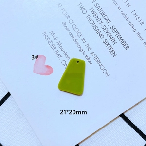Detail eines grasgrünen trapezförmigen Harzanhängers, 21x20mm groß mit oberem Loch