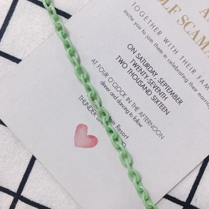 Dettaglio catena in plastica verde menta per collane fai-da-te su sfondo a scacchi