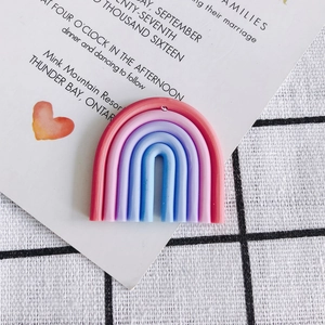 Macro detail of a colorful rainbow resin charm for DIY jewelry making on a white card
