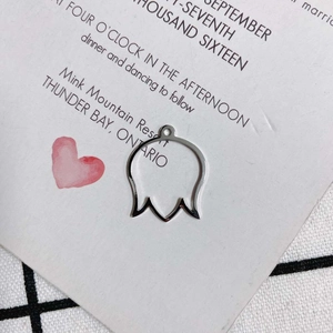 Dettaglio di un ciondolo a campanula in argento su carta decorativa per gioielli fai da te