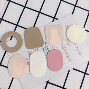 Flat lay of geometric acrylic DIY jewelry charms in matte earth tones and pastel colors