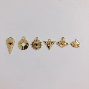 Vue macro détaillée de divers pendentifs mauvais œil plaqués or pour la création de bijoux