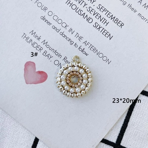 Détail macro d'un pendentif circulaire en alliage doré avec perles et perles roses de 23x20mm