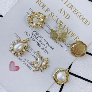 Golden DIY jewelry pendants with pearls and rhinestones on a decorative card