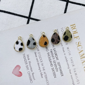 Close-up of teardrop plush animal print charms with gold metal frame for DIY jewelry
