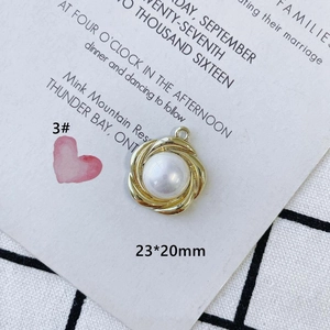 Detail of a 23x20mm white pearl pendant with a golden spiral frame and top loop