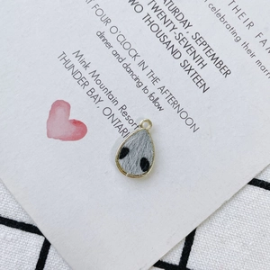 Close-up of grey spotted plush teardrop pendant with gold metal frame for DIY jewelry