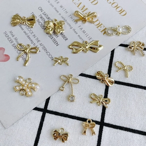 Colección de colgantes de lazo dorado con perlas y pedrería para la creación de joyas DIY