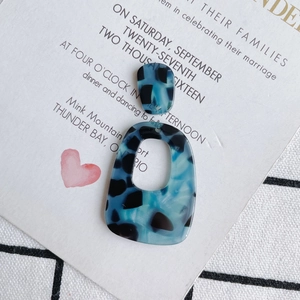 Detail van blauw-zwarte acetaat geometrische oorbel hanger met schildpad textuur