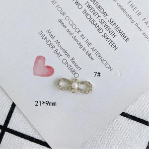 Detalle de colgante infinito dorado con circonitas y perla blanca para joyería DIY