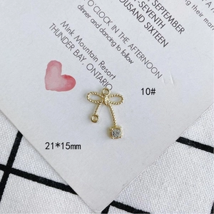 Detalle de colgante de lazo dorado con circonita redonda y textura de cuerda de 21x15mm
