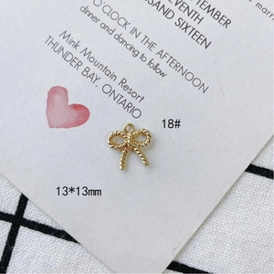 Detalle de colgante de lazo dorado de 13x13mm con textura trenzada y conector