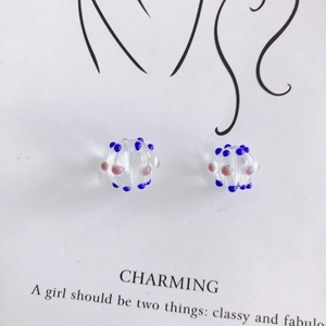 Macro detail of handmade clear glass beads with blue and pink 3D dots for DIY jewelry