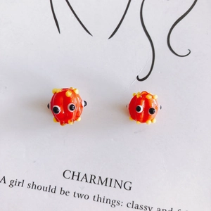 Macro detail of cute orange cartoon glass beads with eyes for DIY jewelry making